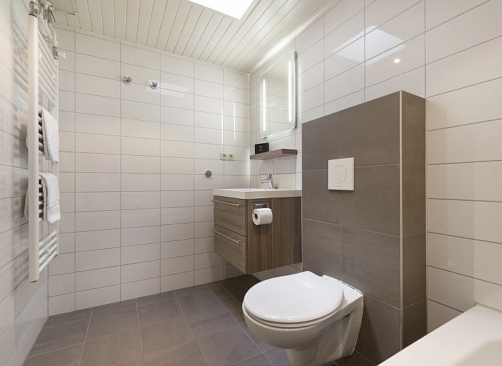 Entspannte Sitzecke im 5-Personen-Bungalow Het Vennenbos 5B1, Hapert, mit bequemem Sofa und dekorativen Details.