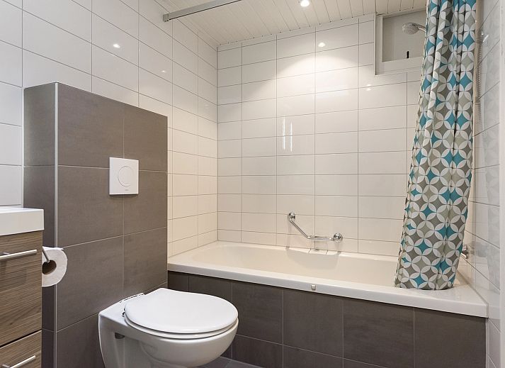 Entspannte Sitzecke im 5-Personen-Bungalow Het Vennenbos 5B1, Hapert, mit bequemem Sofa und dekorativen Details.