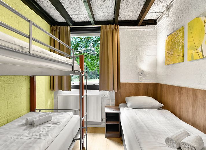 Essecke im 5-Personen-Bungalow Het Vennenbos 5B1, Hapert, mit modernen Stuehlen und einer gemuetlichen Atmosphaere.