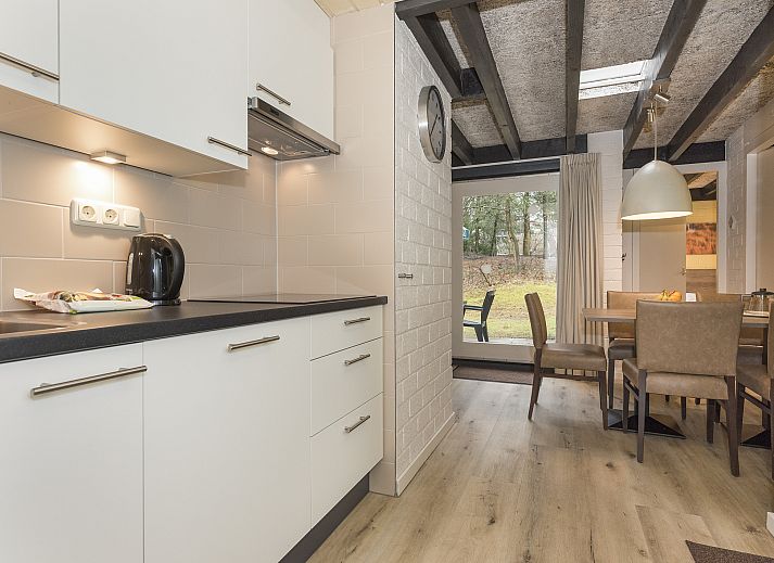 Gezellige woonkamer in Het Vennenbos 5-persoons bungalow 5B2 Hapert, met uitzicht op de groene omgeving.