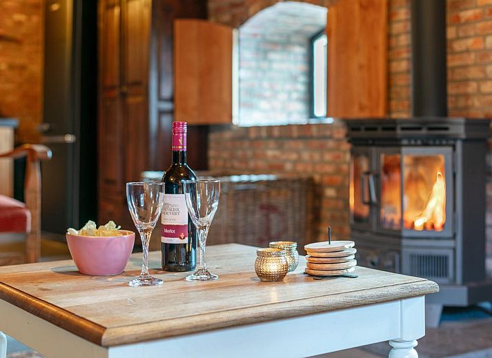 Gezellige woonkamer met houtkachel in De Hoeve I, vakantiehuis in Hulsel, Kempen, Noord Brabant.