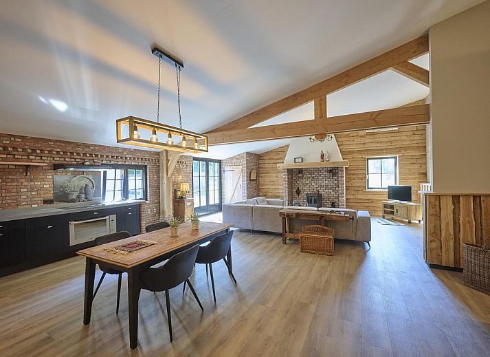 Ruime woonkamer in vakantiehuis De Hoeve III, Hulsel, met houten balken en moderne inrichting in de Kempen, Noord Brabant.