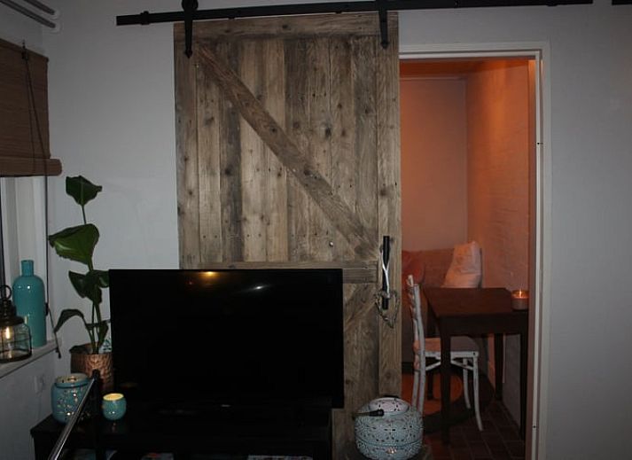 Authentieke houten schuifdeuren in Vakantiehuisje in Oisterwijk, Noord Brabant, voor een rustieke sfeer.