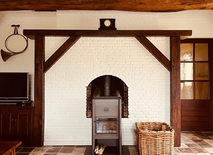 Gezellige binnenruimte van het vakantiehuis in Udenhout met openstaande deuren naar terras.