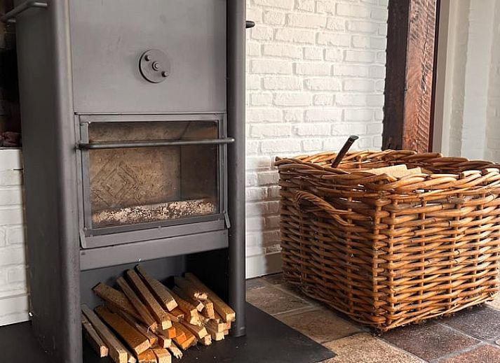 Gezellige binnenruimte van het vakantiehuis in Udenhout met openstaande deuren naar terras.