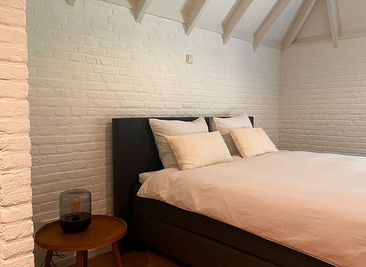 Eettafel met bloemen en uitzicht op groen landschap in vakantiehuis Udenhout, Noord Brabant.