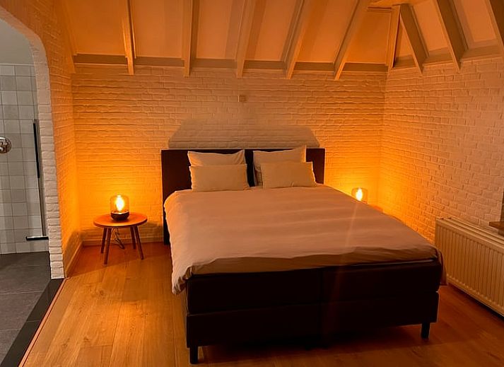 Eettafel met bloemen en uitzicht op groen landschap in vakantiehuis Udenhout, Noord Brabant.