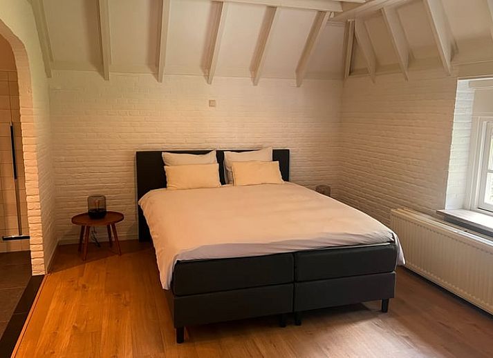 Eettafel met bloemen en uitzicht op groen landschap in vakantiehuis Udenhout, Noord Brabant.