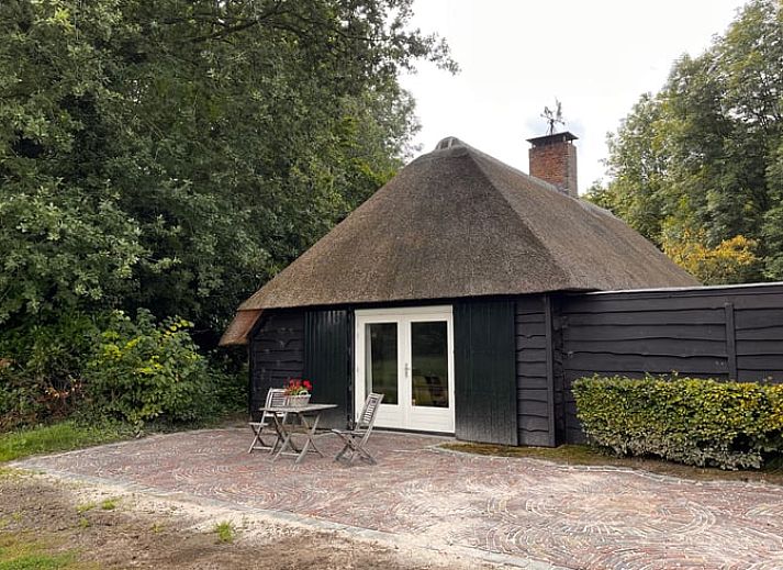 Eettafel met bloemen en uitzicht op groen landschap in vakantiehuis Udenhout, Noord Brabant.