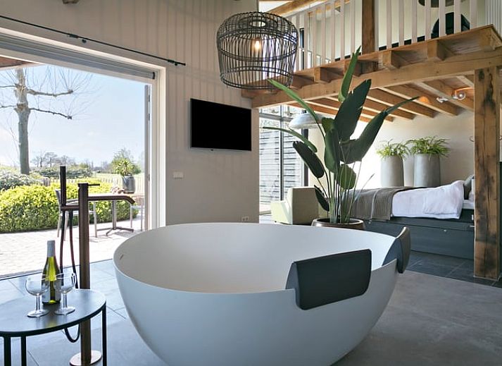 Geraeumiges Schlafzimmer im Ferienhaus in Moergestel, Nordbrabant, mit Holzbalken und bequemem Bett.