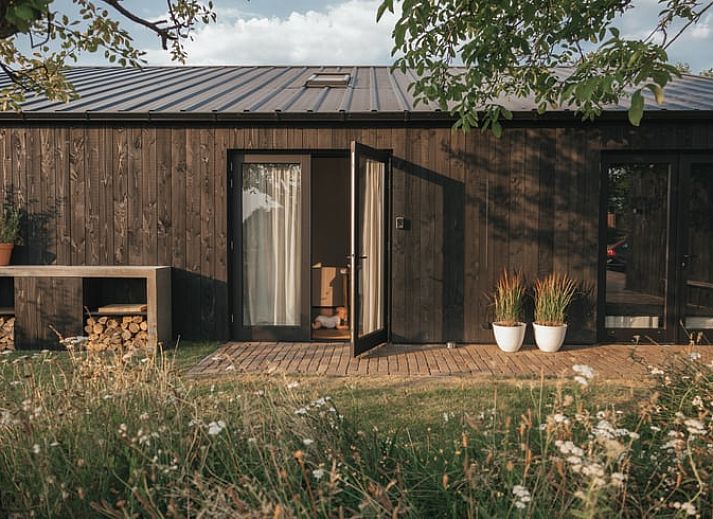 Cozy outdoor area at Holiday Home in Chaam, Heart of Brabant, North Brabant overlooking green fields.
