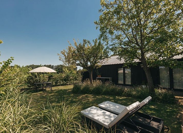 Cozy outdoor area at Holiday Home in Chaam, Heart of Brabant, North Brabant overlooking green fields.