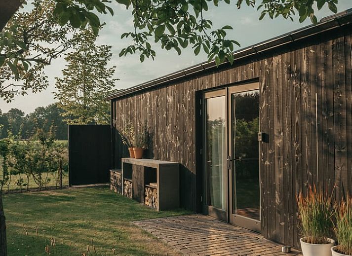 Cozy outdoor area at Holiday Home in Chaam, Heart of Brabant, North Brabant overlooking green fields.