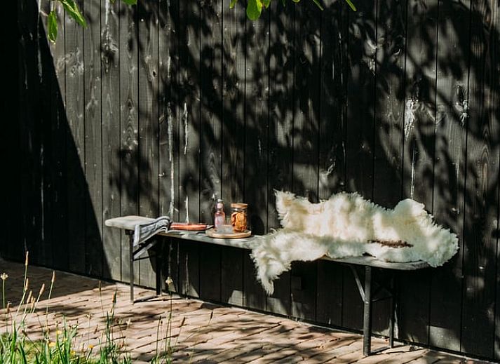 Sunny garden of Holiday Home in Chaam, North Brabant with modern wooden finishes and natural surroundings.