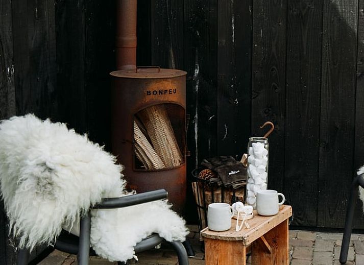 Sunny garden of Holiday Home in Chaam, North Brabant with modern wooden finishes and natural surroundings.