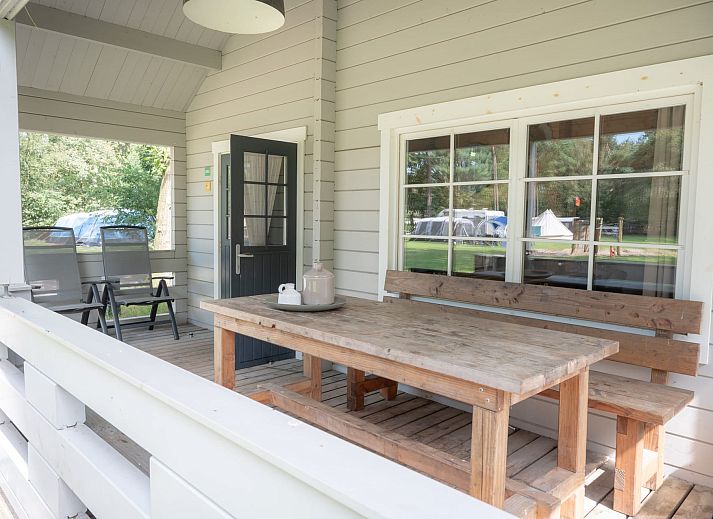 Finnische Lodge Plus in Chaam, Nordbrabant, umgeben von gruener Natur und Baeumen, ideal fuer einen erholsamen Ferienaufenthalt.