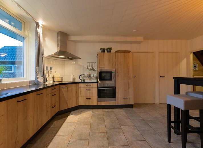 Houten veranda met comfortabele stoelen bij By Romme vakantiehuis in Diessen.