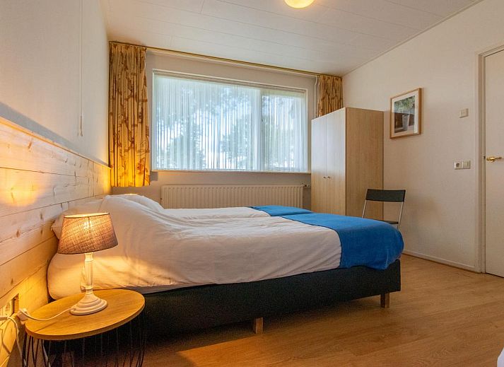 Sfeervolle woonkamer met open haard in By Romme vakantiehuis, Diessen.