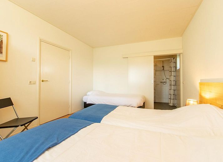 Sfeervolle woonkamer met open haard in By Romme vakantiehuis, Diessen.
