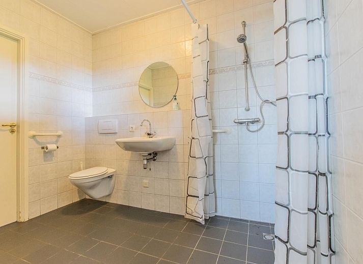 Sfeervolle woonkamer met open haard in By Romme vakantiehuis, Diessen.