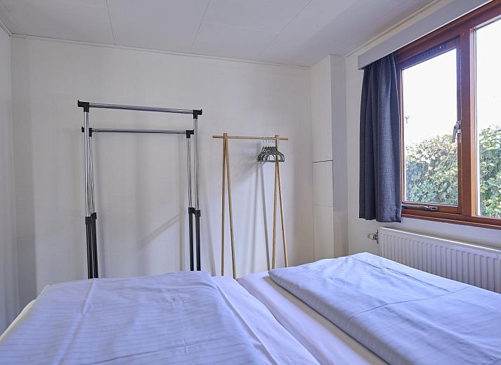 Gezellige zithoek in 't Kaatsheuveltje 7, vakantiehuis in Kaatsheuvel, Noord Brabant, met bloemen en comfortabele bank.