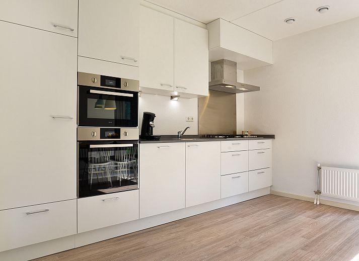 Gezellige woonkamer in 8-persoons vakantiehuis Kaatsheuvel, Hart van Brabant, met open haard en comfortabele zithoek.