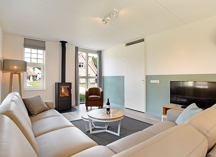 Gezellige woonkamer in 8-persoons vakantiehuis Kaatsheuvel, Hart van Brabant, met open haard en comfortabele zithoek.