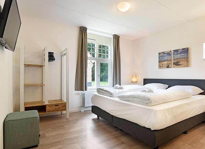 Gezellige woonkamer in 8-persoons vakantiehuis Kaatsheuvel, Hart van Brabant, met open haard en comfortabele zithoek.