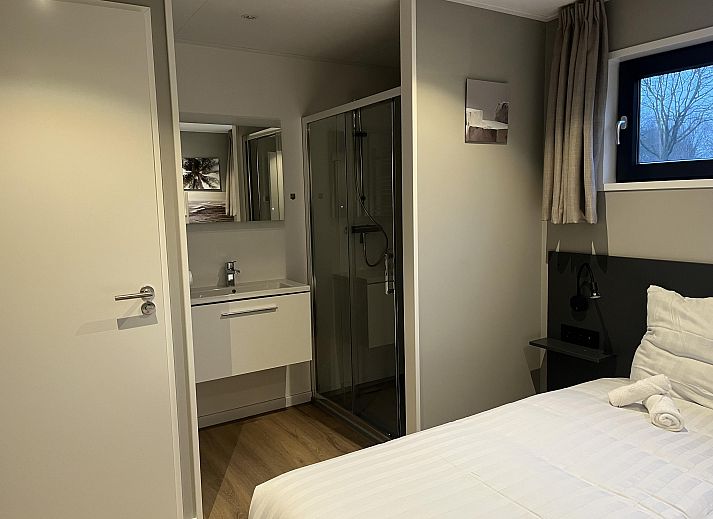 Stylish living room of the Detached house in Kaatsheuvel, Heart of Brabant, overlooking the green garden through large windows.