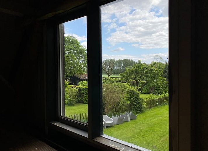 Gemuetliches Wohnzimmer im Ferienhaus in Leende, Nordbrabant mit bequemem Sofa und Gartenblick. Perfekt zum Entspannen.