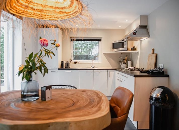 Moderne Kueche im Ferienhaus in Leende, Nordbrabant, komplett mit Geraeten und Blick auf die Natur.