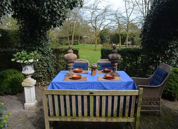 Geniet van de serene tuin met zithoek bij Vakantiehuisje in Sleeuwijk, Hart van Brabant, Noord Brabant.