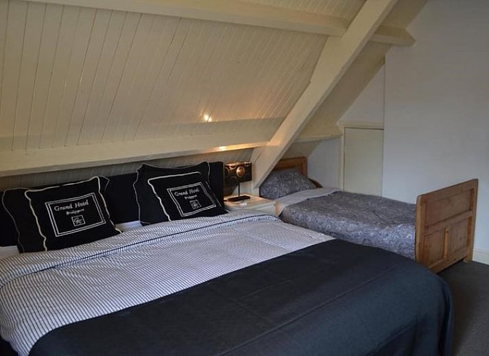 Gezellig terras bij Vakantiehuisje in Sleeuwijk, Noord Brabant, met rustieke eettafel en comfortabele stoelen omringd door groene natuur.