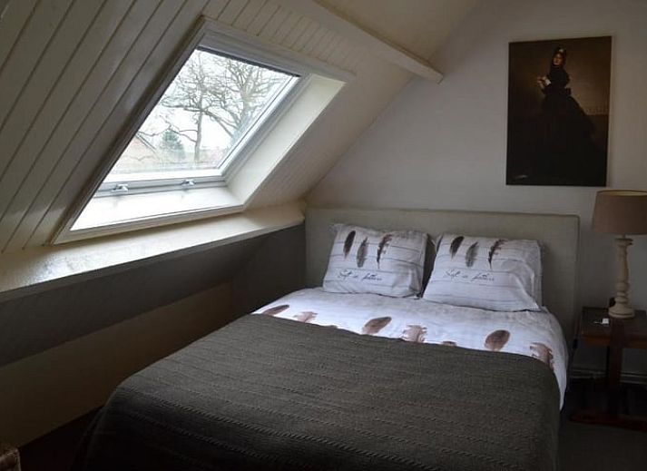 Gezellig terras bij Vakantiehuisje in Sleeuwijk, Noord Brabant, met rustieke eettafel en comfortabele stoelen omringd door groene natuur.