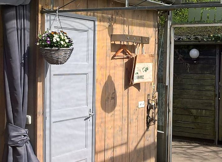 Lichte en ruime binnenruimte van Vakantiehuisje in Hank, Noord Brabant, met glazen wanden en comfortabele zithoek, ideaal voor ontspanning.