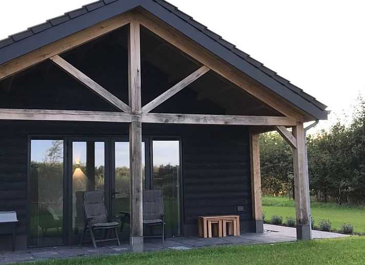 Stylishly decorated living room of Holiday home in Boxtel, North Brabant, with comfortable furniture and a flower wall.
