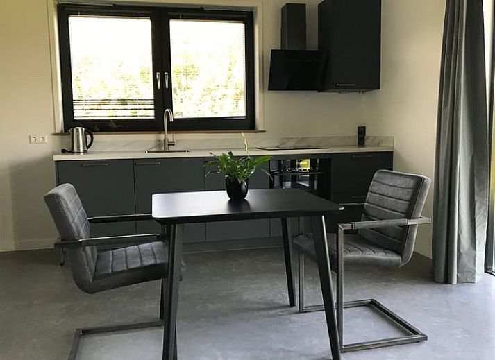 Stylishly decorated living room of Holiday home in Boxtel, North Brabant, with comfortable furniture and a flower wall.