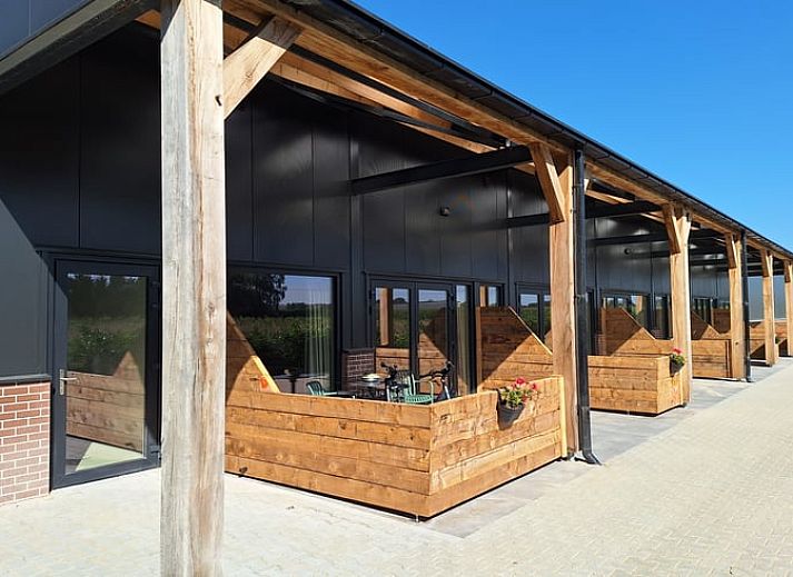 Moderne Veranda im Huisje in De Moer, Ferienhaus in Nordbrabant mit Blick auf die gruene Umgebung.