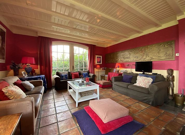 Terras van De Meerenhoeve in Mill, Noord Brabant, met houten meubels en uitzicht op de tuin.