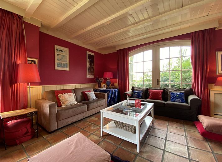 Terras van De Meerenhoeve in Mill, Noord Brabant, met houten meubels en uitzicht op de tuin.