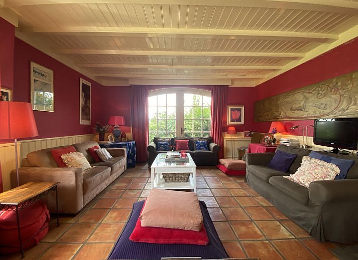 Terras van De Meerenhoeve in Mill, Noord Brabant, met houten meubels en uitzicht op de tuin.