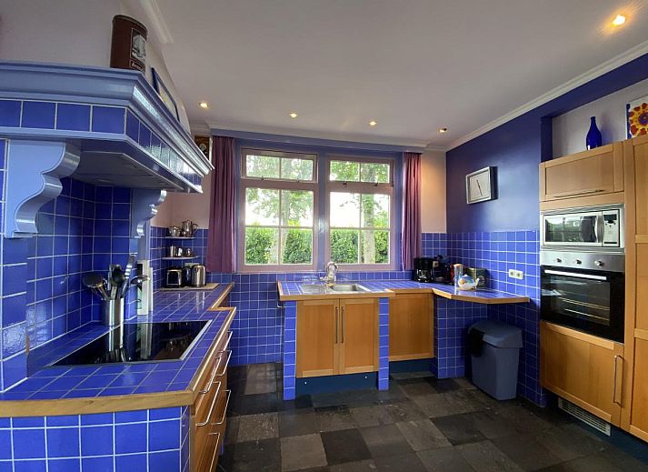 Buitenaanzicht van De Meerenhoeve in Mill, Noord Brabant, met bakstenen muren en groene omgeving.