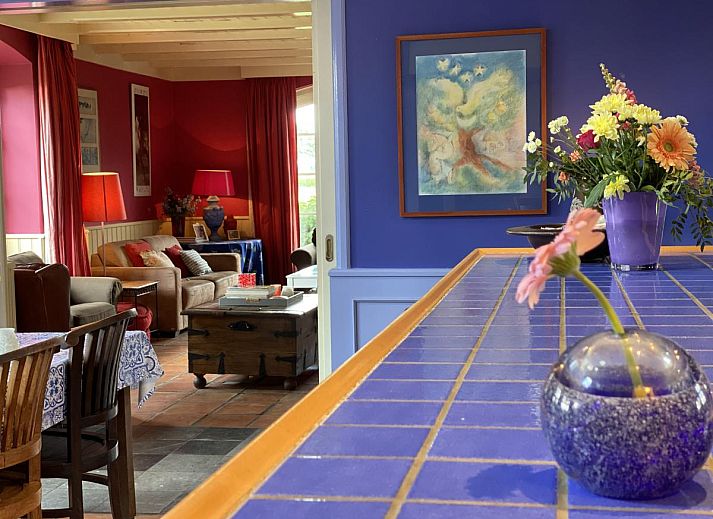 Gezellige binnenruimte van De Meerenhoeve in Mill, Noord Brabant, met comfortabele leren fauteuils.