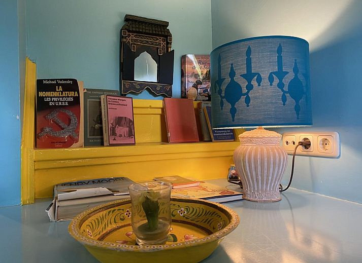 Sfeervolle woonkamer van De Meerenhoeve in Mill, Noord Brabant, met open haard en houten meubels.