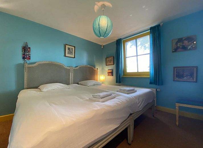 Sfeervolle woonkamer van De Meerenhoeve in Mill, Noord Brabant, met open haard en houten meubels.