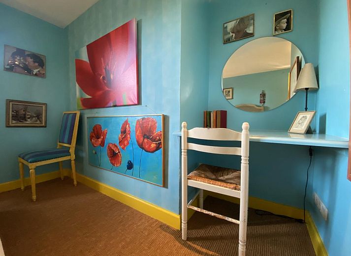 Sfeervolle woonkamer van De Meerenhoeve in Mill, Noord Brabant, met open haard en houten meubels.