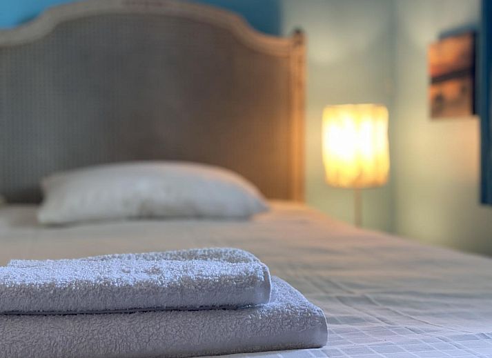 Sfeervolle woonkamer van De Meerenhoeve in Mill, Noord Brabant, met open haard en houten meubels.