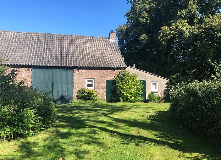 Vorderseite des Ferienhauses in Mill, Nordost-Brabant, mit grossem Garten und blauem Himmel.