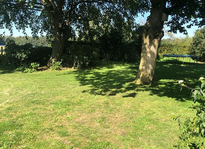 Vorderseite des Ferienhauses in Mill, Nordost-Brabant, mit grossem Garten und blauem Himmel.