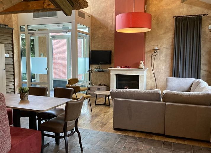 Gezellige woonkamer in Vakantiehuis in Schaijk, Noordoost Brabant met moderne keuken en uitzicht op de tuin.